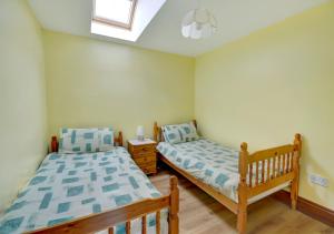 Saint MawganTrembleath Parlour的一间卧室设有两张床和窗户。