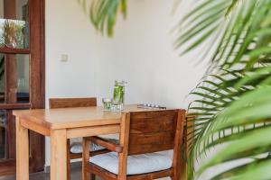 威廉斯塔德ABC Lodges Curacao的木桌和椅子,在植物间