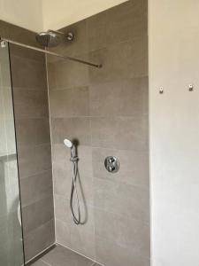 斯卡恩Fin ny moderniseret lejlighed i Skagen.的浴室里设有玻璃门淋浴