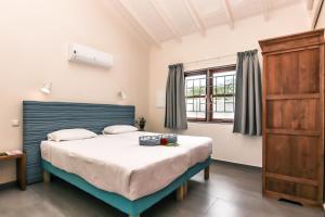 威廉斯塔德ABC Lodges Curacao的一间卧室设有一张大床和一个窗户。