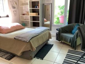 南特Maisonnette Nantes的卧室配有床、椅子和窗户。