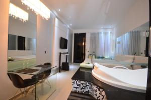 莫索罗VERT MOTEL MOSSORO的一间带大浴缸的大浴室和一间客厅
