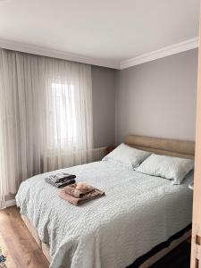 Karşıyakaan apartment in a decent neighborhood的一间卧室配有一张床,床上有毛巾