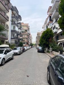 Karşıyakaan apartment in a decent neighborhood的路边有汽车的街道