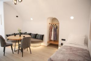 安坡里奥圣托里尼Luxury Canava的一间卧室配有一张床、一张桌子和一张沙发
