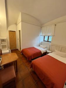 Středokluky圣普罗科帕酒店的客房设有两张床、一张桌子和一张书桌。