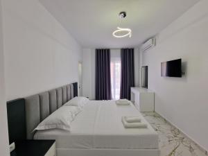 卡萨米尔Vila Klari的白色卧室配有一张带白色床单的大床