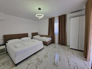 卡萨米尔Vila Klari的一间设有两张床的卧室,铺有大理石地板。