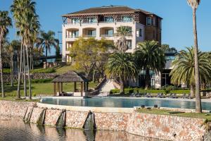 里奥卢汉索菲特的瑞色瓦卡达尔酒店的一座带游泳池和棕榈树的建筑