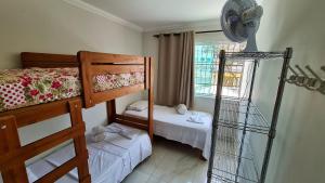 贝洛奥里藏特Casa confortável e segura na região da Pampulha的一间卧室设有两张双层床和风扇
