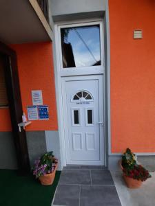 维尼察SUN RIVER KOLPA Ap Big的两棵植物的橙色建筑上的白色门