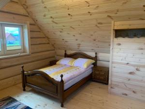 JabłonkaZagroda na Borach - Domek的小木屋内一间卧室,配有一张床