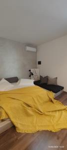 格勒姆Residence La Pineta的卧室配有黄色毯子,位于床上