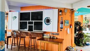 Seine Bight VillageCoral Cove Inn的厨房设有带凳子和窗户的酒吧