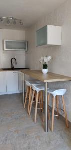 萨尔格米纳Le Cygne, appartement de standing en hyper-centre的厨房配有木桌和一些白色椅子