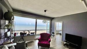 赞德沃特Ocean BreezeApartment: WakeUp 2 Sound of the Waves的客厅配有粉红色的椅子,享有海景