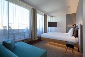 里斯本Moxy Lisbon City的酒店客房设有一张床和一个大窗户
