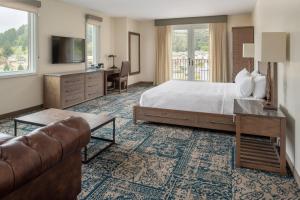 斯科茨谷Four Points by Sheraton Santa Cruz Scotts Valley的酒店客房,配有床和沙发