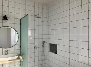 玛尔盖姆拉בסנדלים: חאן בוטיק בגולן的白色瓷砖浴室设有水槽和镜子