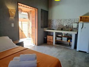 圣若热岛Casa Om - Vila de São Jorge的一间卧室配有一张床,厨房配有冰箱