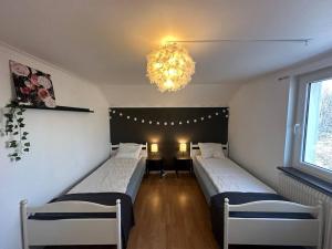 埃斯基尔斯蒂纳Modernt & rymligt sommarhus på landet- Bubbelpool的一间卧室配有两张床和吊灯。