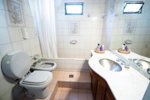 门多萨Fuxia House Hostel的白色的浴室设有卫生间、水槽和卫生间。