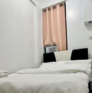 马尼拉Private room with AC and fan at EKG House Rental的白色卧室设有一张带窗户的床