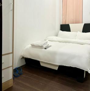 马尼拉Private room with AC and fan at EKG House Rental的一间卧室配有带白色床单和枕头的床。