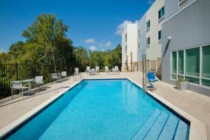 尼斯维尔TownePlace Suites by Marriott Niceville Eglin AFB Area的一座带椅子的游泳池以及一座建筑