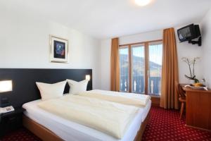 上萨克森中央酒店的卧室设有一张白色大床和一扇窗户。