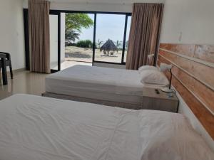 卡诺阿斯德蓬萨尔Las Hamacas的一间卧室设有两张床,外面设有一个窗口,带骆驼