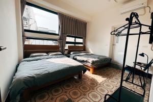 鴉埠客棧x南華大旅社的一间卧室,配有两张床