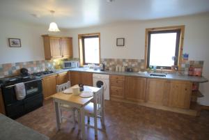 ToabCampston的厨房配有木制橱柜、桌子和炉灶。