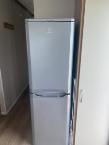 新罗姆尼Cosy holiday home at Romney Sands的厨房里设有白色冰箱冰柜