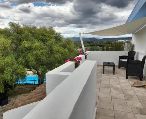 OnifaiAgriturismo Palas De Serra Country Resort的阳台拥有白色的围栏和鲜花。