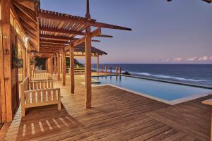 Ponta MamoliAloha 10 I 4Bed Villa with Stunning Sea View Pool的一个带游泳池和房子的木甲板