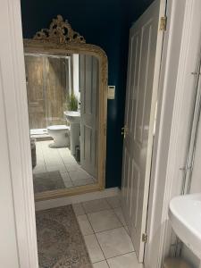 什鲁斯伯里Boutique Shrewsbury Suites的浴室设有镜子、盥洗盆和卫生间