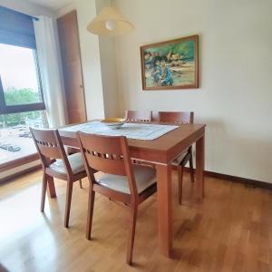 比利亚维西奥萨Apartamento Seronda的一张餐桌,配有四把椅子和一幅画