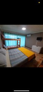 伊瓜苏港Guembe al Rio Hostel的一间卧室配有一张带黄色毯子的大床