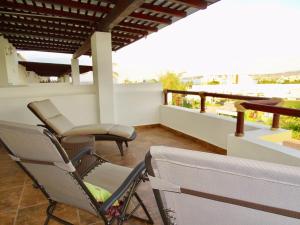布塞里亚斯Casa Los Amores的阳台的天井配有2把椅子和1张桌子