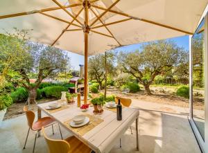 普利维伦吉斯Villa Serenity Sustainable Luxury Retreat by GuestLee的露台上的桌子和遮阳伞