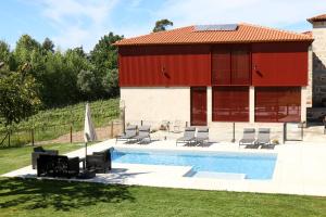 布拉加Quinta de Chousas - Braga - Agroturismo的一座带游泳池的建筑和一座红色的建筑