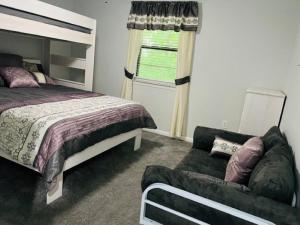 温泉城Resort Home on .5 Wooded Acres Sleeps up to 12. Firepit for Smores!的一间卧室配有一张床和一张沙发