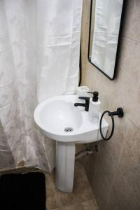 蒙得维的亚Exclusive on Rio Negro的浴室设有白色水槽和镜子