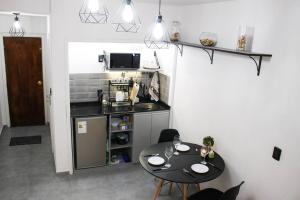 蒙得维的亚Exclusive on Rio Negro的一间小厨房,配有一张黑桌子和一张桌子及椅子