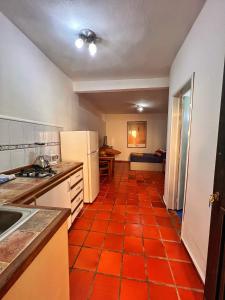 PampatarUn rinconcito en Pampatar的厨房铺有橙色瓷砖地板。