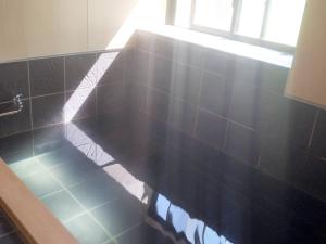 妙高池の平温泉 ロッジ コクハ的浴室设有黑色瓷砖台面和窗户