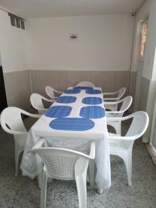 波哥大HOTEL BOGOTA AIRPORT DORADO的一张带白色椅子的桌子和一张蓝白色的桌子