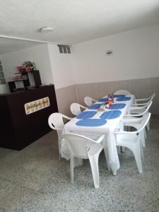 波哥大HOTEL BOGOTA AIRPORT DORADO的客房内的白色桌椅