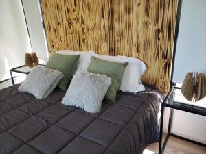 韦尔塔格兰德Aires de mar的一张带绿色和白色枕头的床